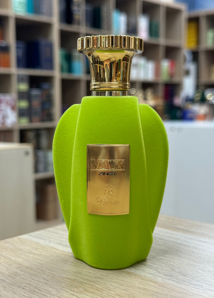 Frasco del perfume Paris Corner Voux Zingy en color verde con placa dorada sobre mesa en tienda de perfumes
